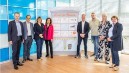 Groepsfoto van de acht bestuurders die het commitment voor Zwitch Almere ondertekenden, poseerend rondom een paneel met logo's . In het midden, v.l.n.r.: P. Rotering (Zorggroep Almere), M. Seelen (Flevoziekenhuis), N. Nieuwenhuizen (gemeente Almere), N. Tellegen (Flever), S. van de Sant (Woonzorg Flevoland), Y. Zwijnenburg (Stichting Moving Up), J. Veltman (directeur ROC van Flevoland) en L. Voorhorst (Triade Vitree) .